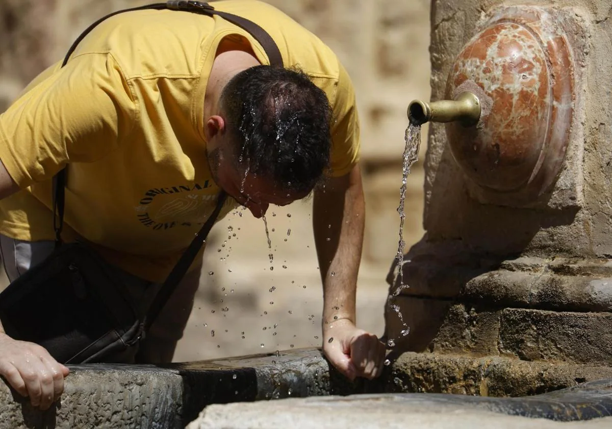 Un hombre se refresca en una fuente de la capital cordobesa