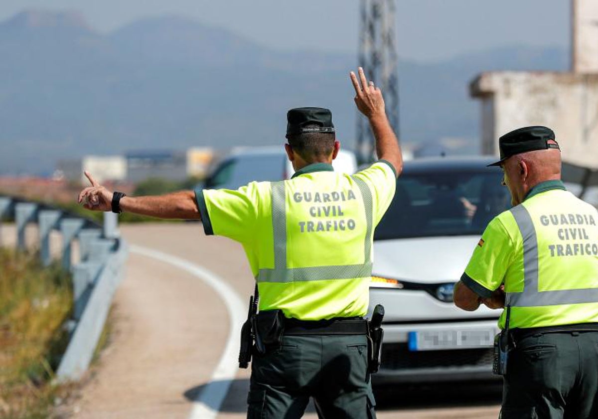 Un agente de la Guardia Civil de Tráfico da el alto a un vehículo