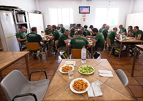 Imagen secundaria 1 - Parte de la brica 703 lleva avituallamiento a un retén que les da el relevo en Casares. Las brigadas siempre comen juntas y eso sirve para hacer equipo. Juan Umbría tiende la ropa en una de las treguas del fuego. 
