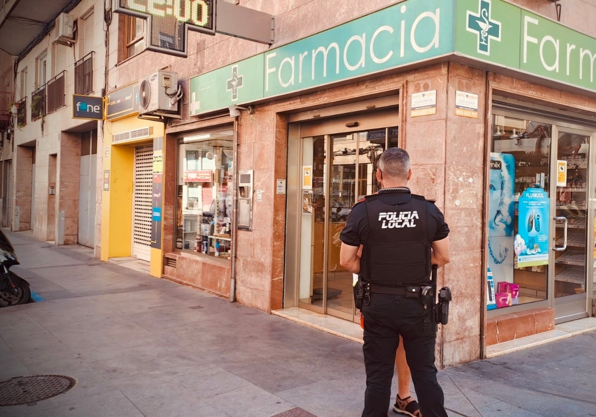 Imagen de archivo de un policía local frente a una farmacia de Elche