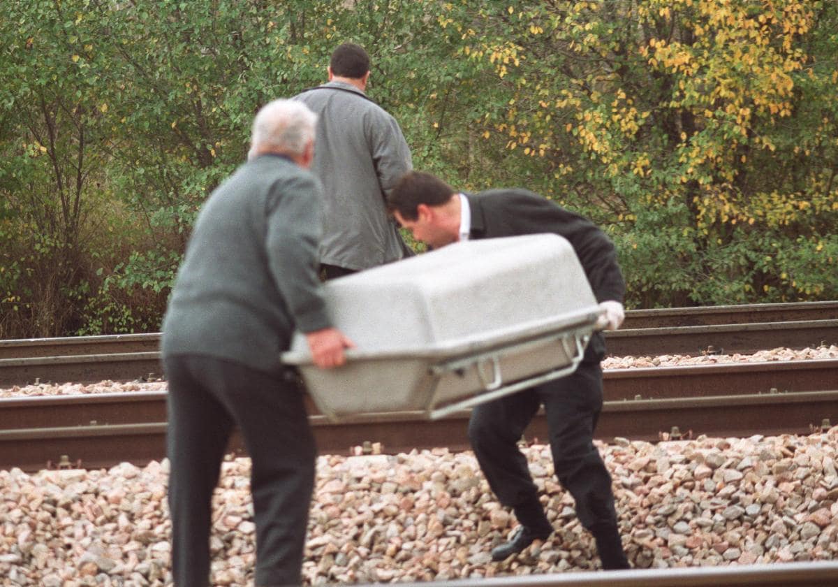 Dos personas recogen el cuerpo de una persona tras sucidarse en las vías del tren