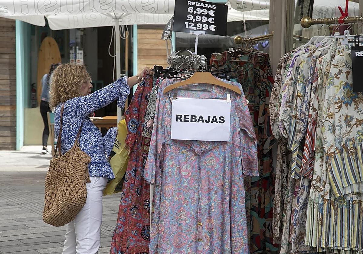 Una clienta mira vestidos rebajados en una tienda del Centro
