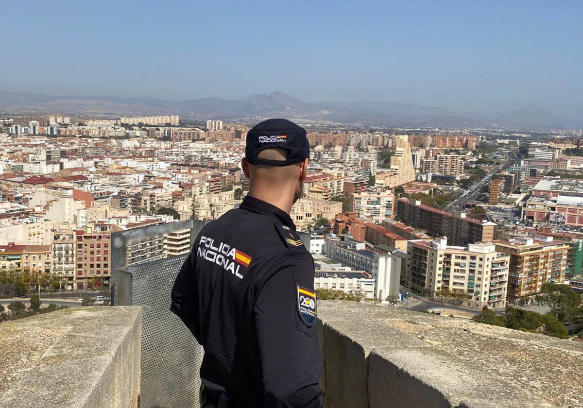 Un policía nacional observa la ciudad de Alicante desde el castillo de San Fernando