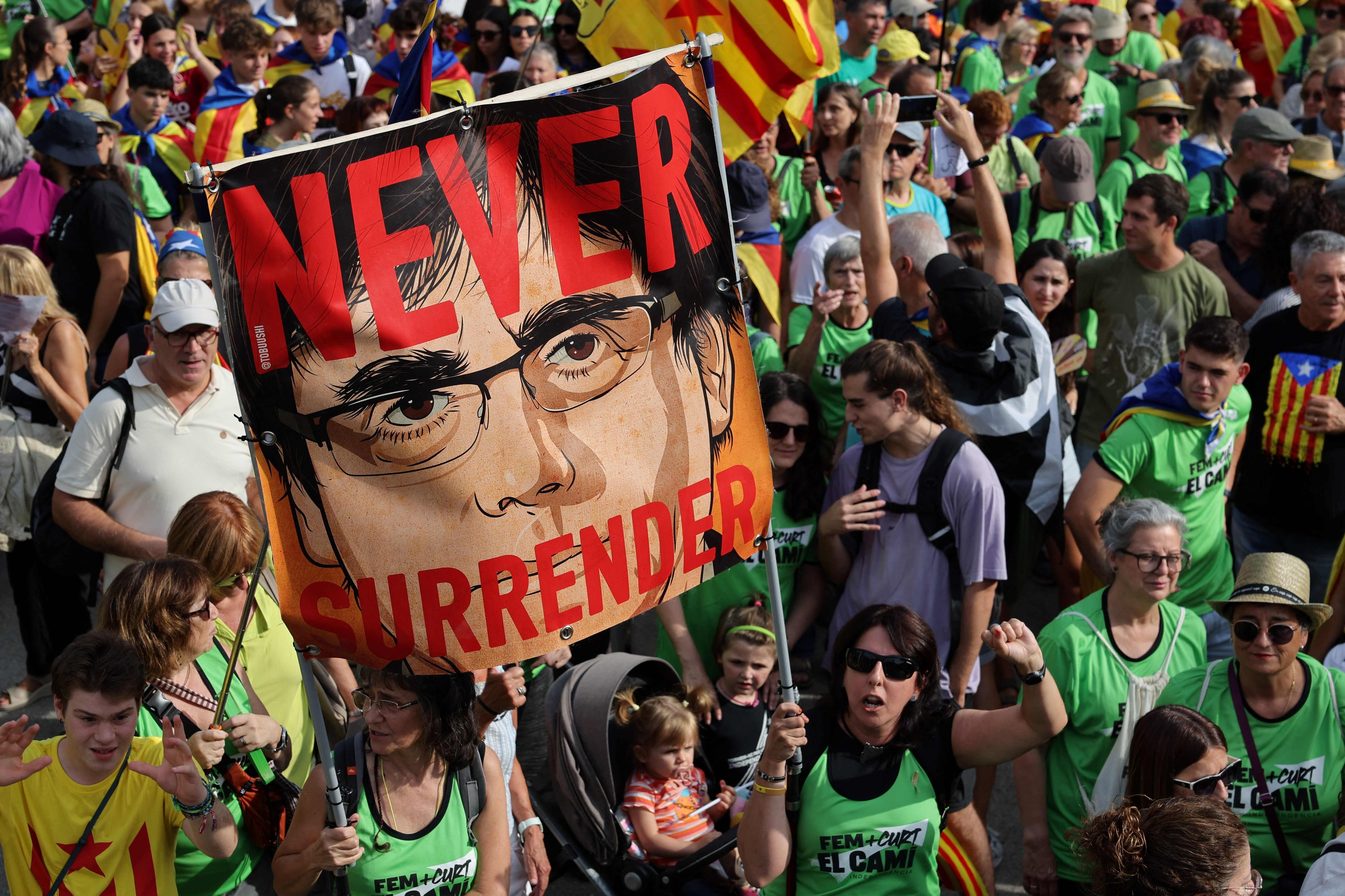 Pancarta con la cara de Puigdemont y el lema 'Nunca rendirse' en la manifestación de Barcelona.