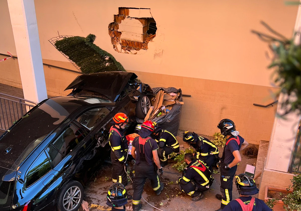 Los bomberos trabajan para retirar el vehículo accidentado