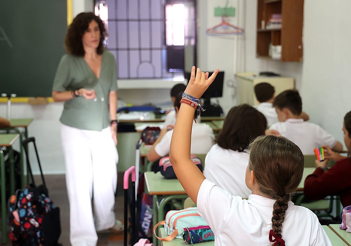 Una alumna levanta la mano durante el primer día de clase