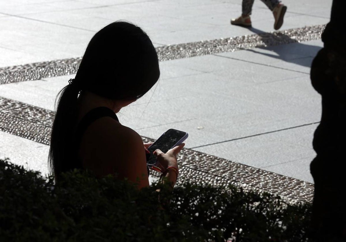 Un grupo de jóvenes usando aplicaciones de mensajería en la plaza de las Tendillas