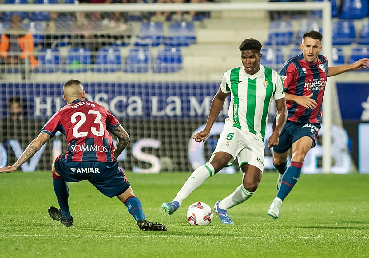 Marvel conduce el balón ante dos jugadores del Huesca en El Alcoraz