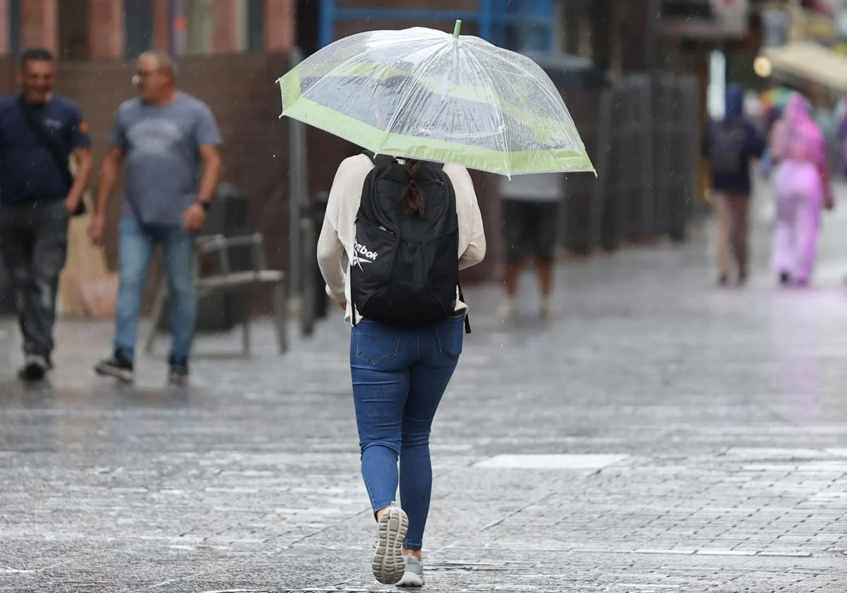 Una joven camina bajo la lluvia en el Centro de Córdoba