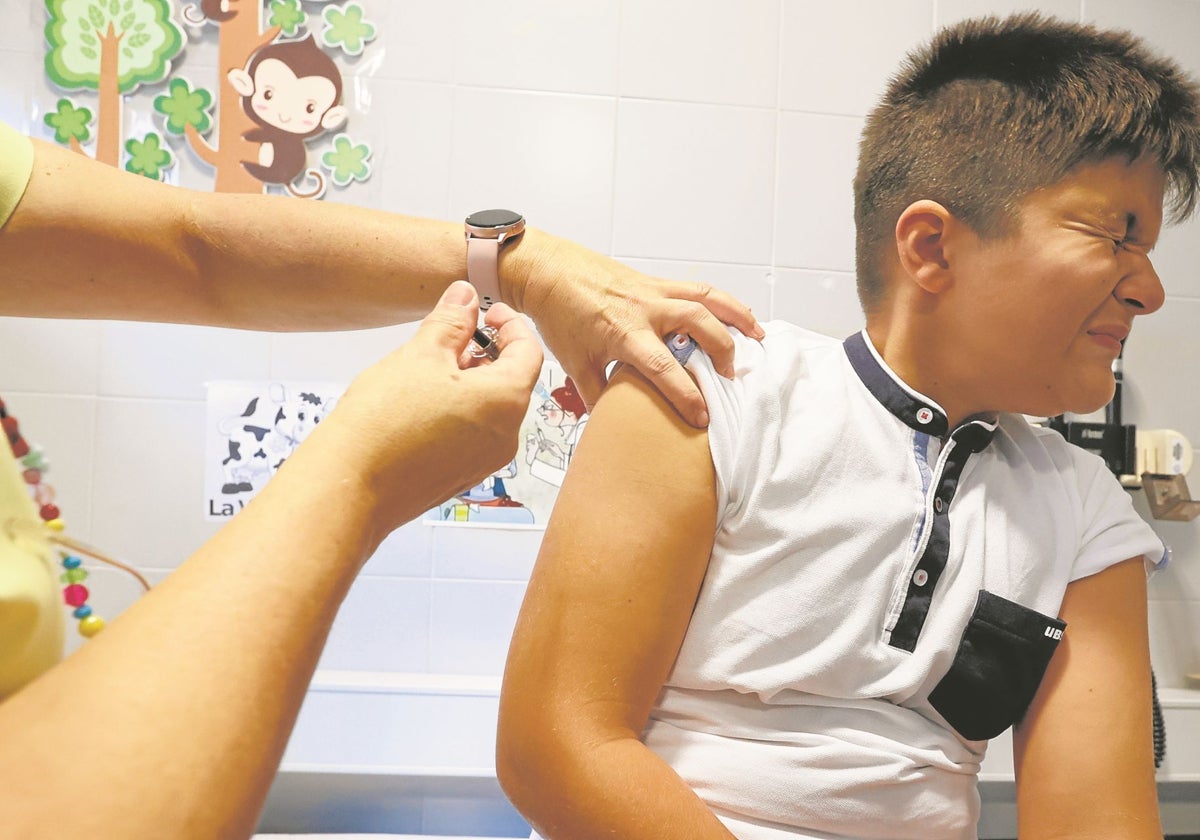 Un niño recibe una vacuna en un centro escolar