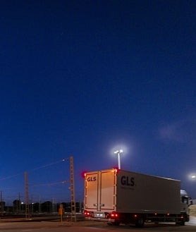 Imagen secundaria 2 - Arriba, las jaulas con los paquetes entran en el tren en la estación de El Bercial. Abajo, izquierda, desde la cabina del tren se ve el camión que le espera, preparado para la descarga. Derecha, el camión, ya con los paquetes, toma el camino hacia el almacén central de GLS