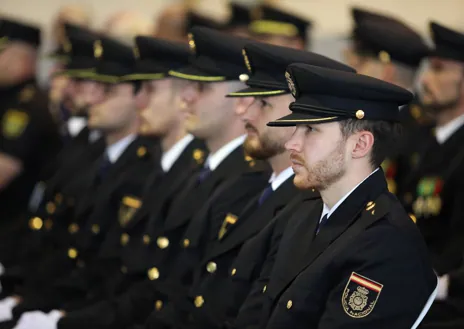 Imagen secundaria 1 - La imagen que presidió el acto; policías uniformados entre los asistentes y el alcalde de Toledo, Carlos Velázquez, condecorando a un agente 