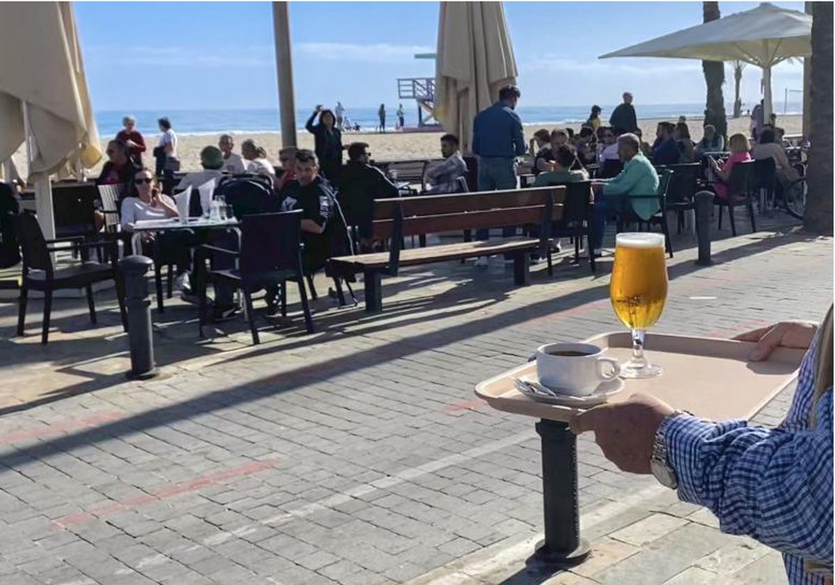 Un camarero se dispone a servir unas consumiciones en la terraza de un bar