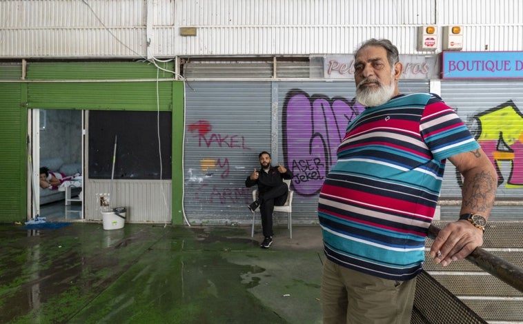 Imagen principal - Arriba, Alfonso, en el local que ha reformado para convertirlo en su hogar. Abajo, a la izquierda, una panorámica del centro comercial. A la derecha, una antigua joyería abandonada