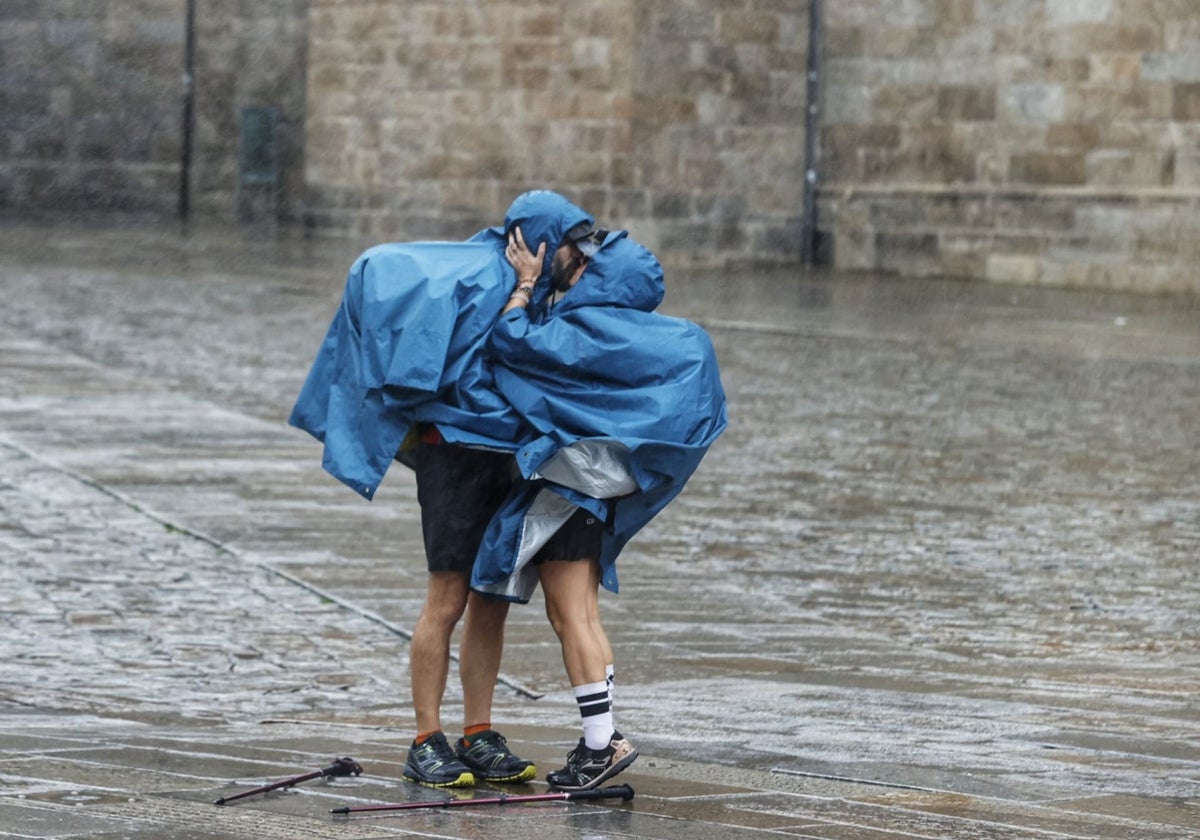 Dos peregrinos a su llegada a Santiago de Compostela en plena borrasca Kirk
