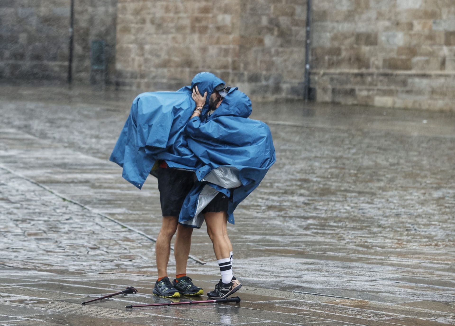 Dos peregrinos a su llegada a la Plaza del Obradoiro en Santiago, en plena borrasca