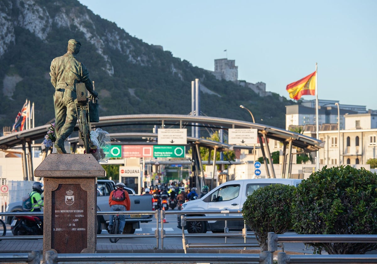 En primer plano, monumento al trabajador transfronterizo en La Línea, con la Verja y el Peñón al fondo