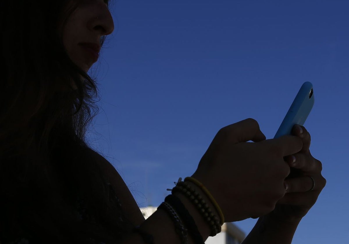 Una mujer consulta su teléfono móvil en una imagen de archivo