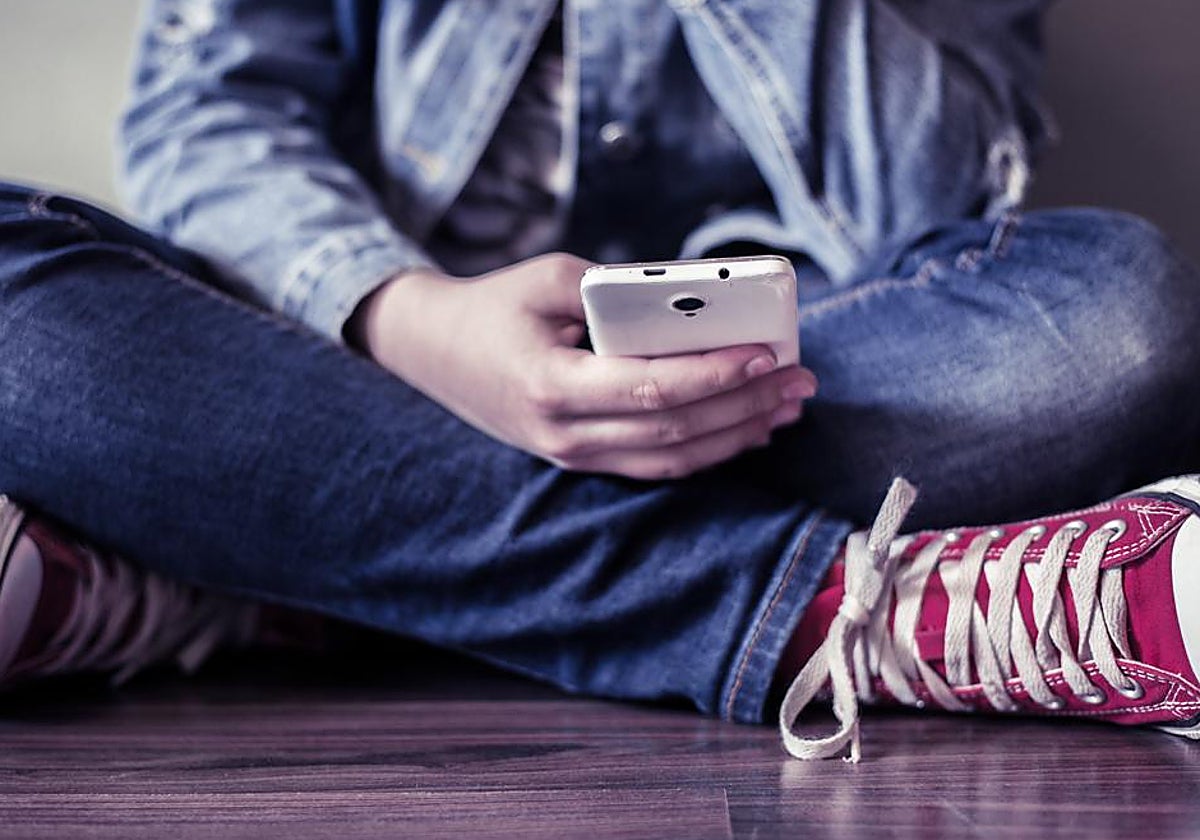 Una adolescente con su teléfono móvil