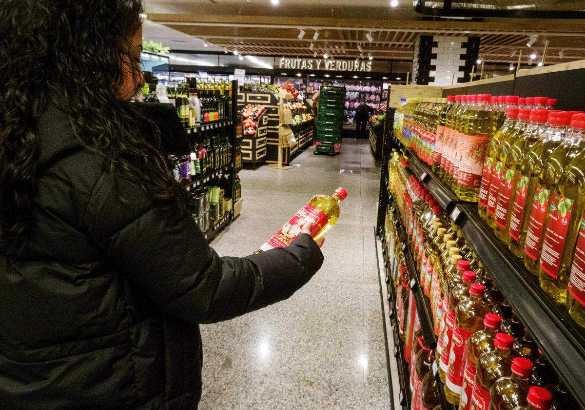 Una mujer compra aceite en un supermercado