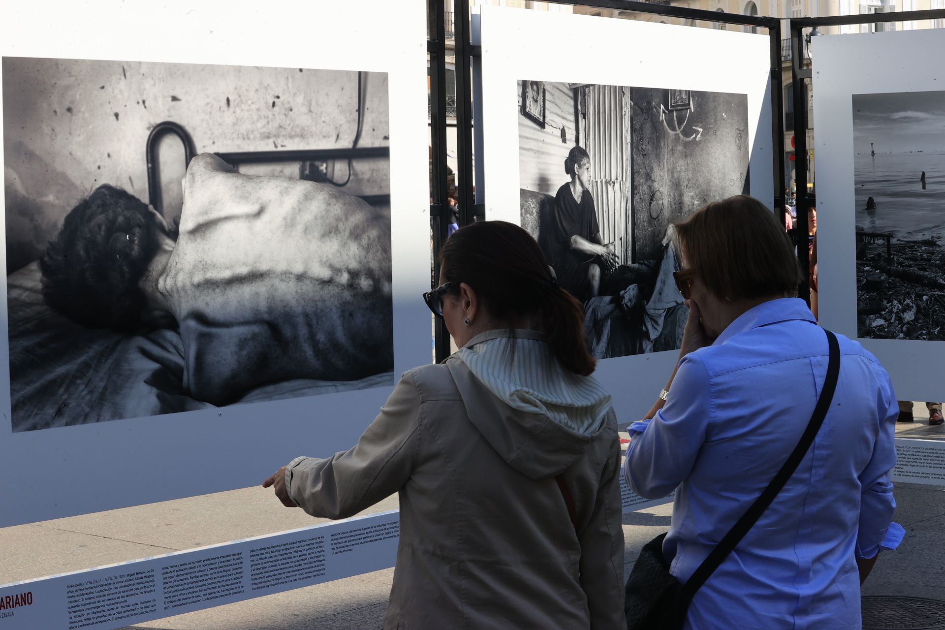 Dos mujeres contemplan estremecidas la imagen de Miguel Blanco, 28 años,  víctima de desnutrición extrema, en el barrio Alto de Milagros, en Maracaibo.