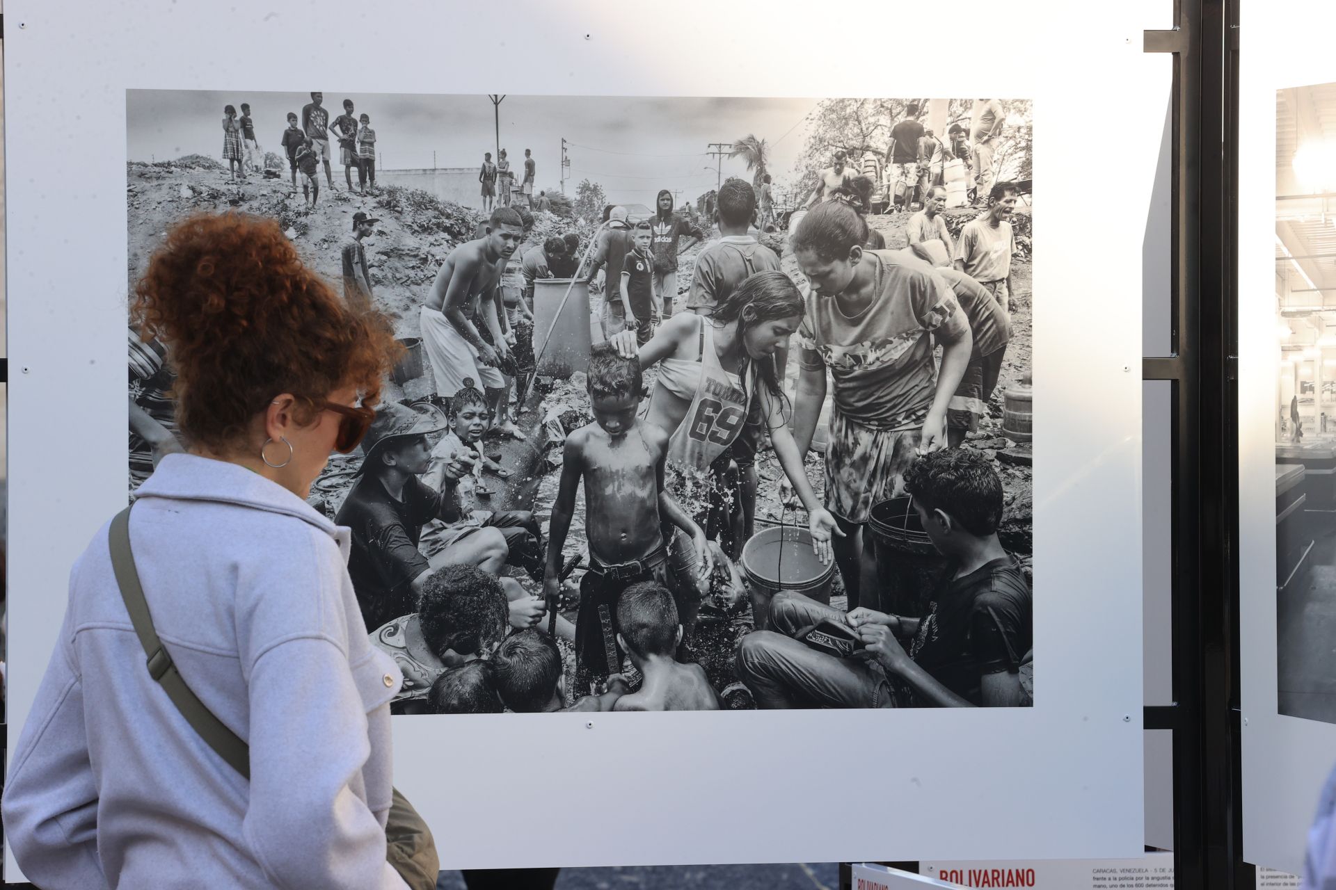 Una ciudadana contemplando otra de las imágenes, de las duras condiciones en que sobreviven miles de venezolanos en la actualidad 