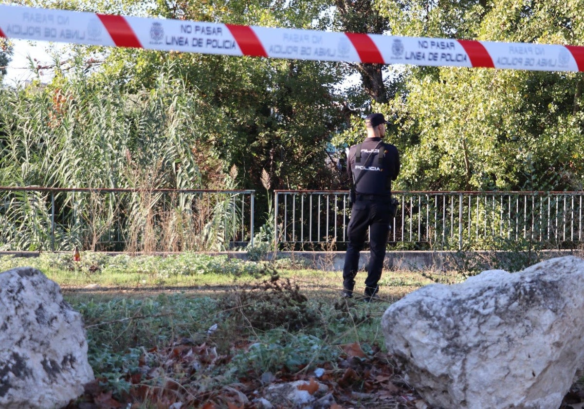 Un agente en la zona acordonada del río Lucena donde apareció el cadáver de este vecino