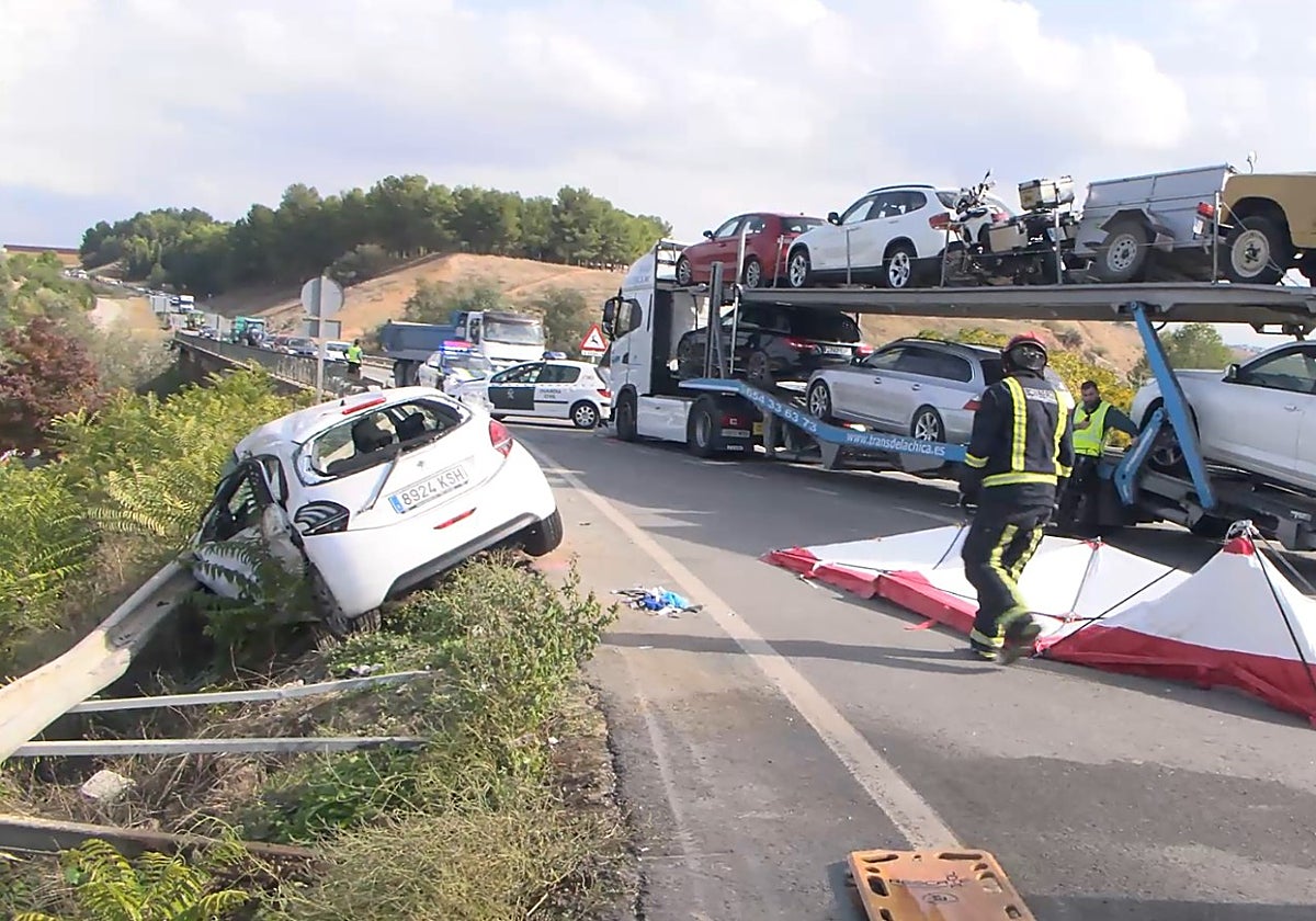 Estado en que ha quedado el coche siniestrado junto al tráiler que portaba coches en la carretera A-318 (Puente Genil)
