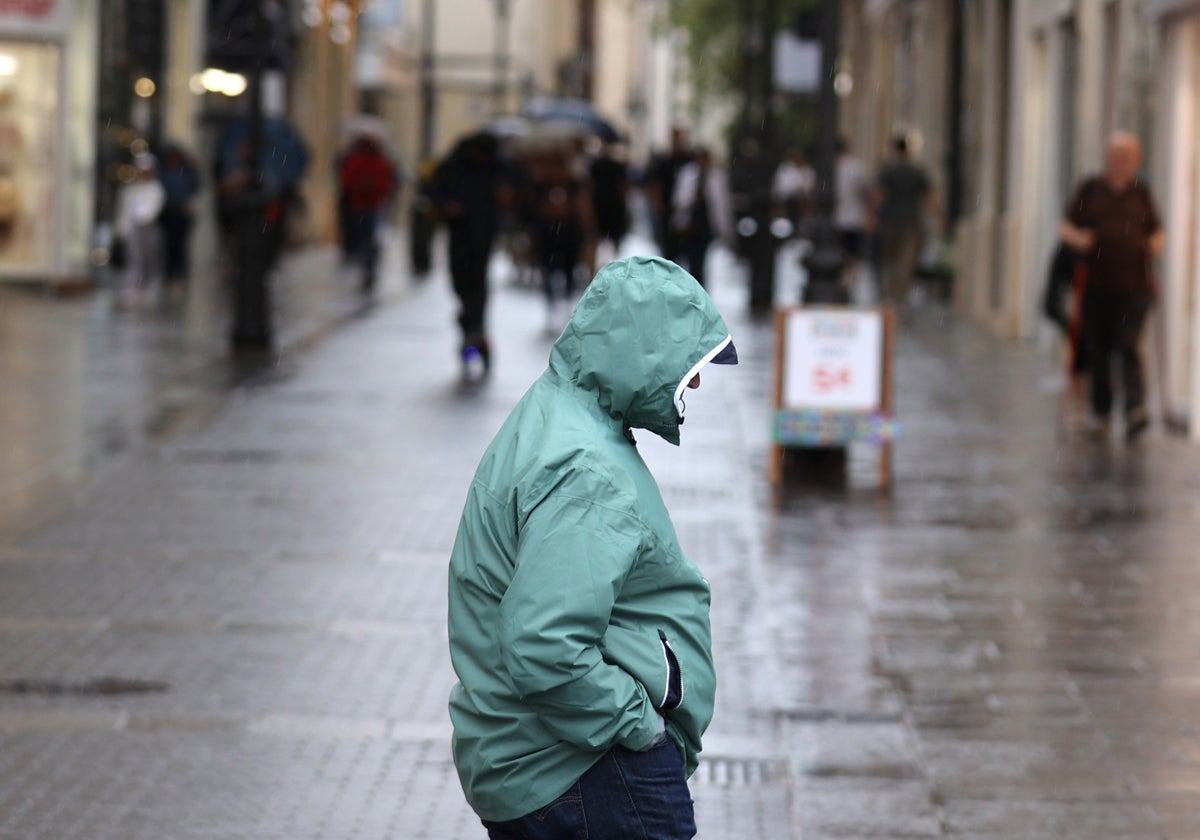 Un hombre pasea bajo la lluvia po el Centro de Córdoba