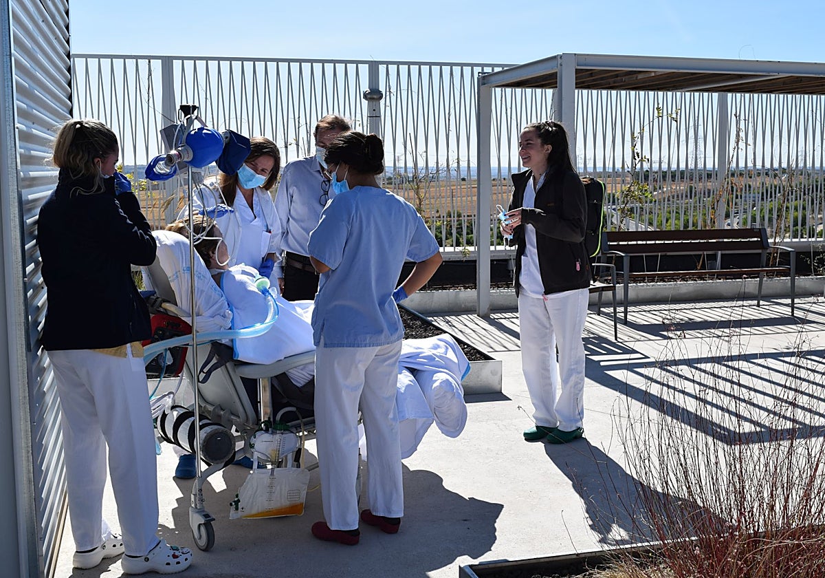 Personal sanitario con una de las pacientes de la UCI, durante uno de los paseos