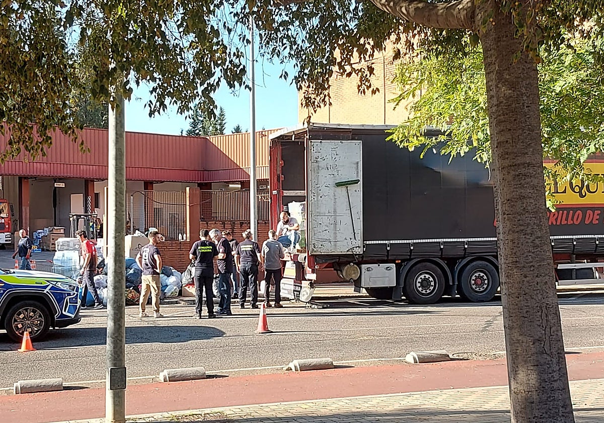 Bomberos y policías cargan los alimentos donados estas últimas horas por los cordobeses en un tráiler