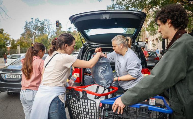 Imagen principal - Vecinos y voluntarios clasifican las donaciones en el punto de recogida habilitado por el Ayuntamiento de Madrid 