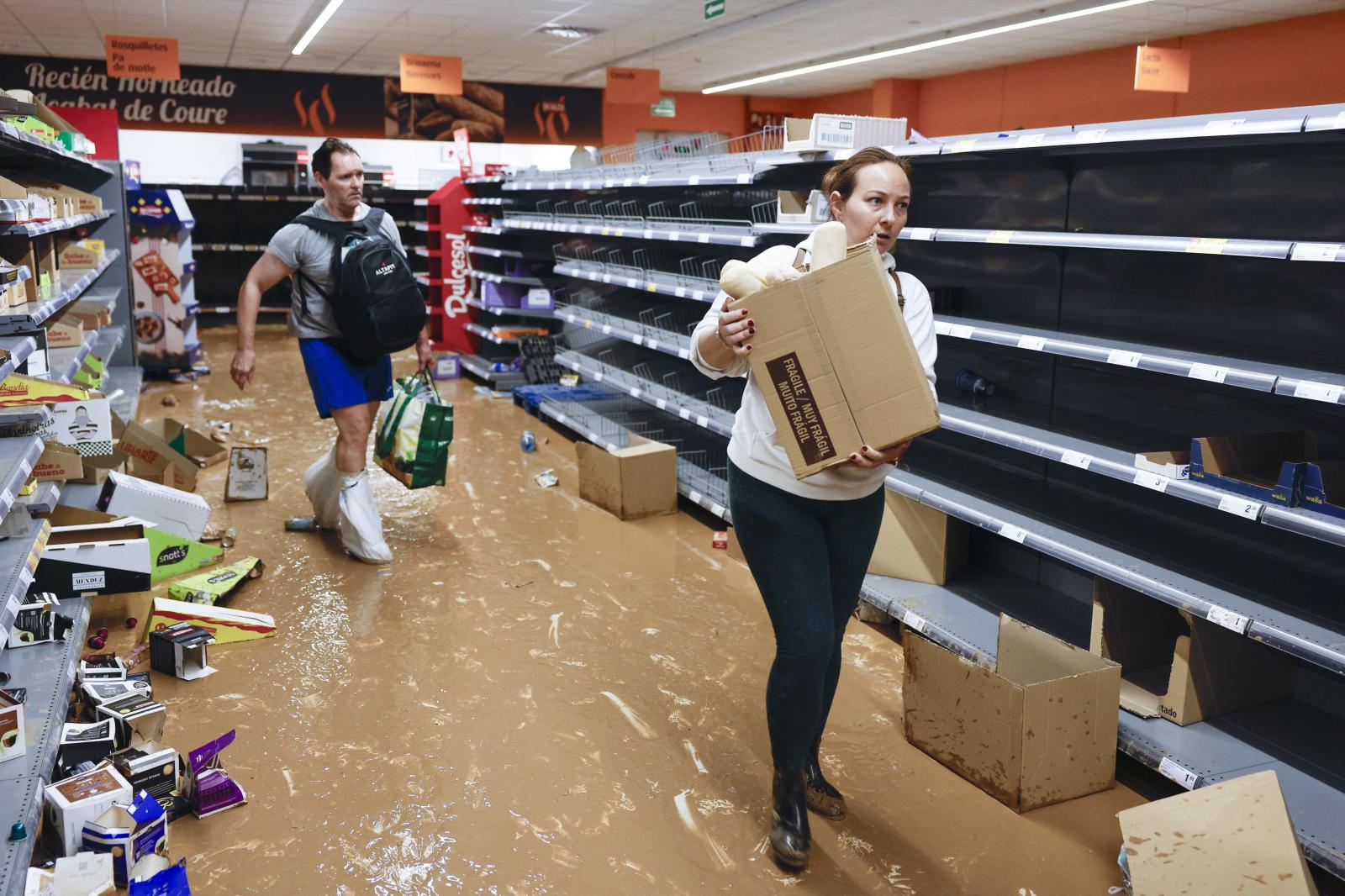 Varios residentes recogen alimentos en un supermercado en la localidad de Paiporta, Valencia