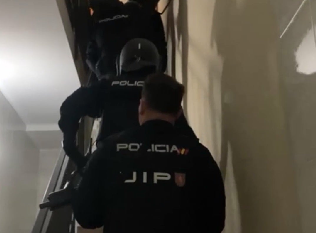 Policía Nacional subiendo unas escaleras hacia el piso donde operaba la banda