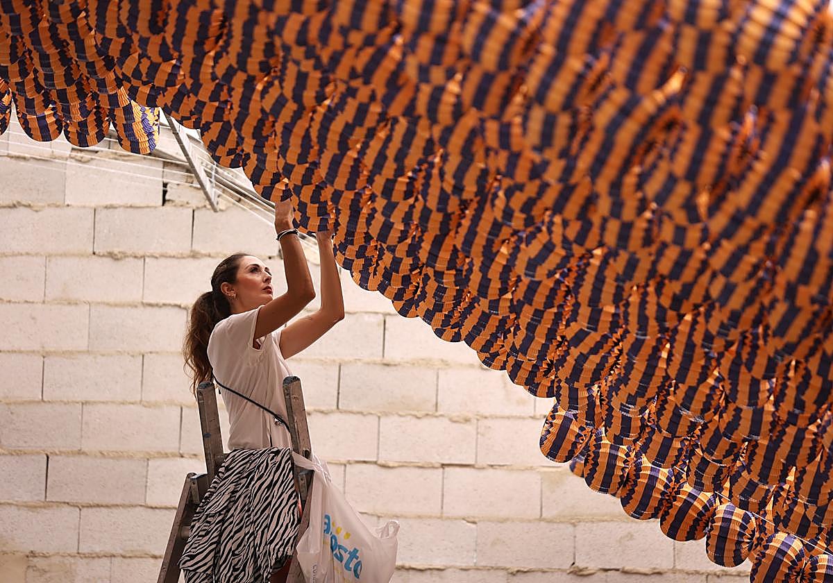 Una mujer trabaja en la decoración de una caseta para la Feria de 2024