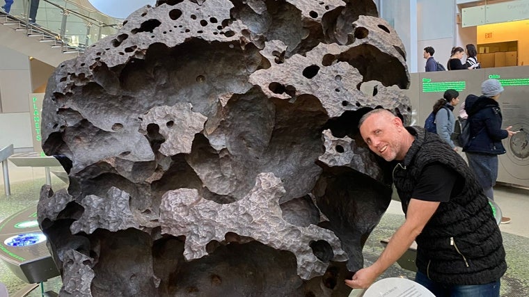 Javier Cáceres posa con el meteorito Willamette en Nueva York