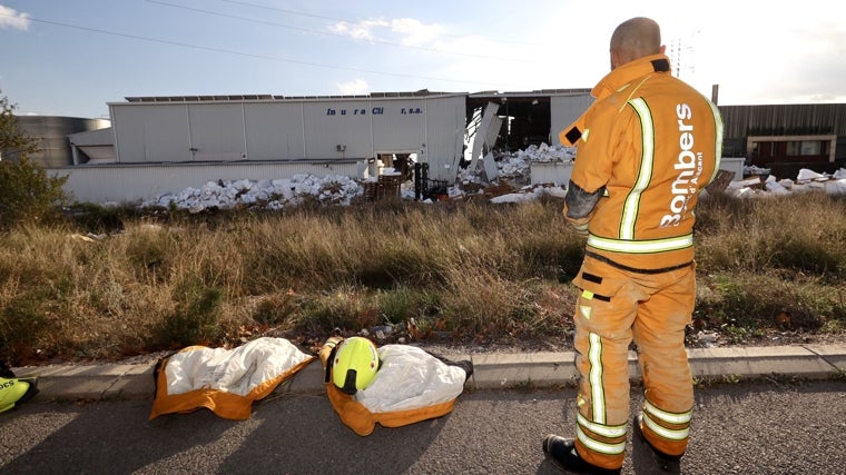 Imagen de un bombero frente a la nave industrial afectada en Ibi (Alicante)