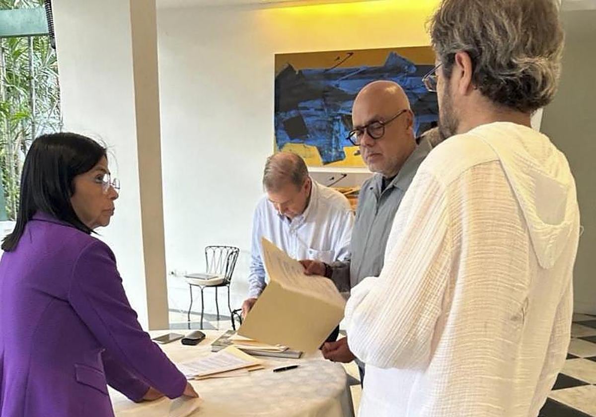 Momento en el que Edmundo González firma el documento en la residencia del embajador Ramón Santos en presencia de Delcy Rodríguez y Jorge Rodríguez el pasado 7 de septiembre