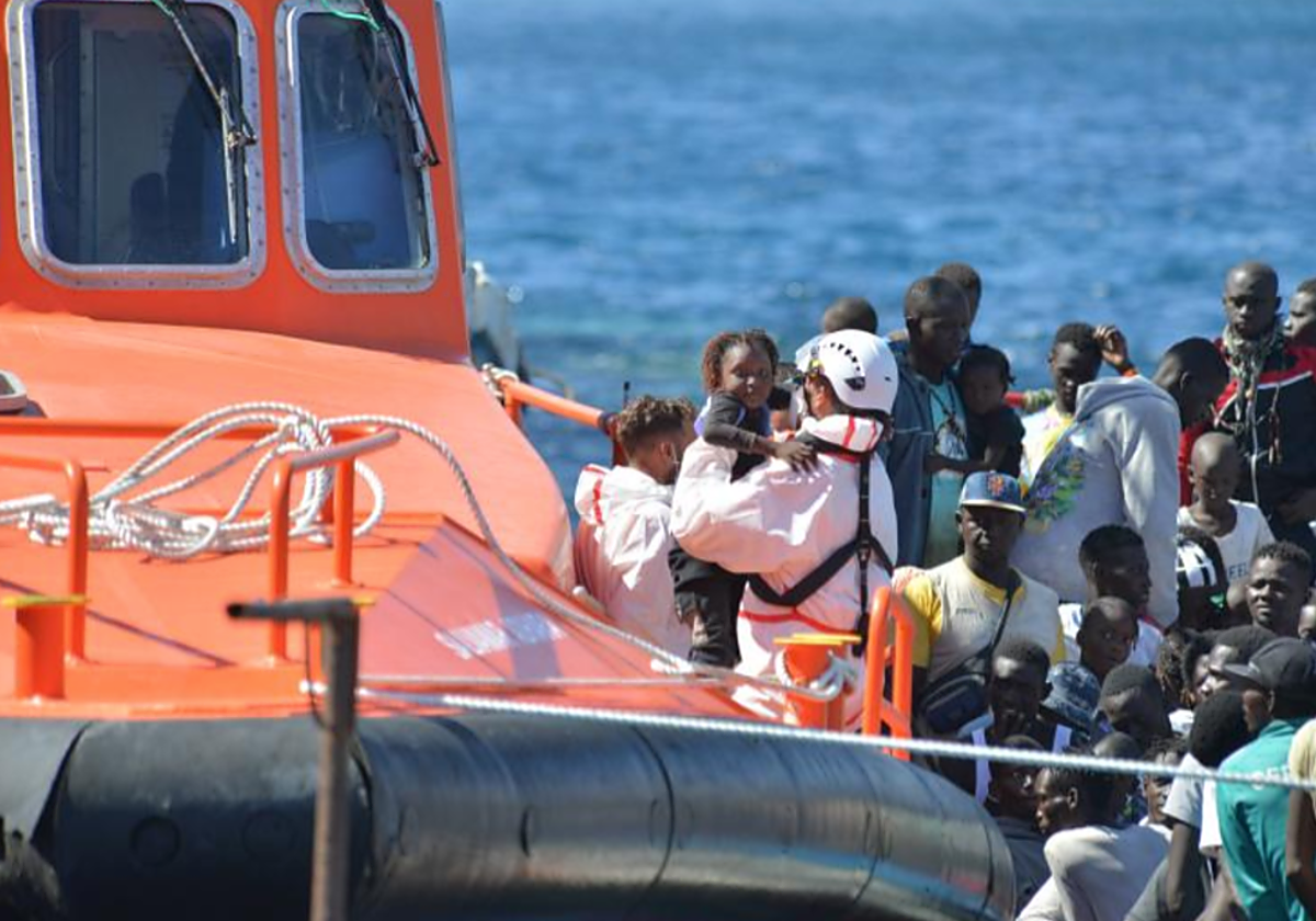 Un rescatador coge en brazos a una niña en el desembarco de la salvamar en El Hierro