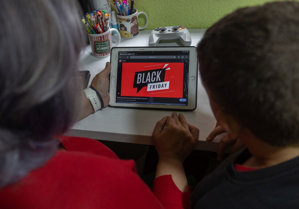 Dos personas con una tablet ven publicidad del Black Friday