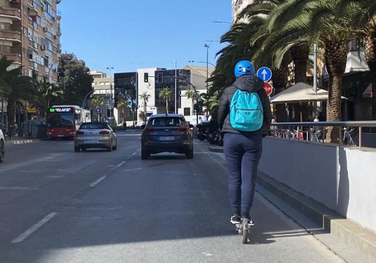 Imagen de archivo de un joven circulando por ciudad en un patinete eléctrico