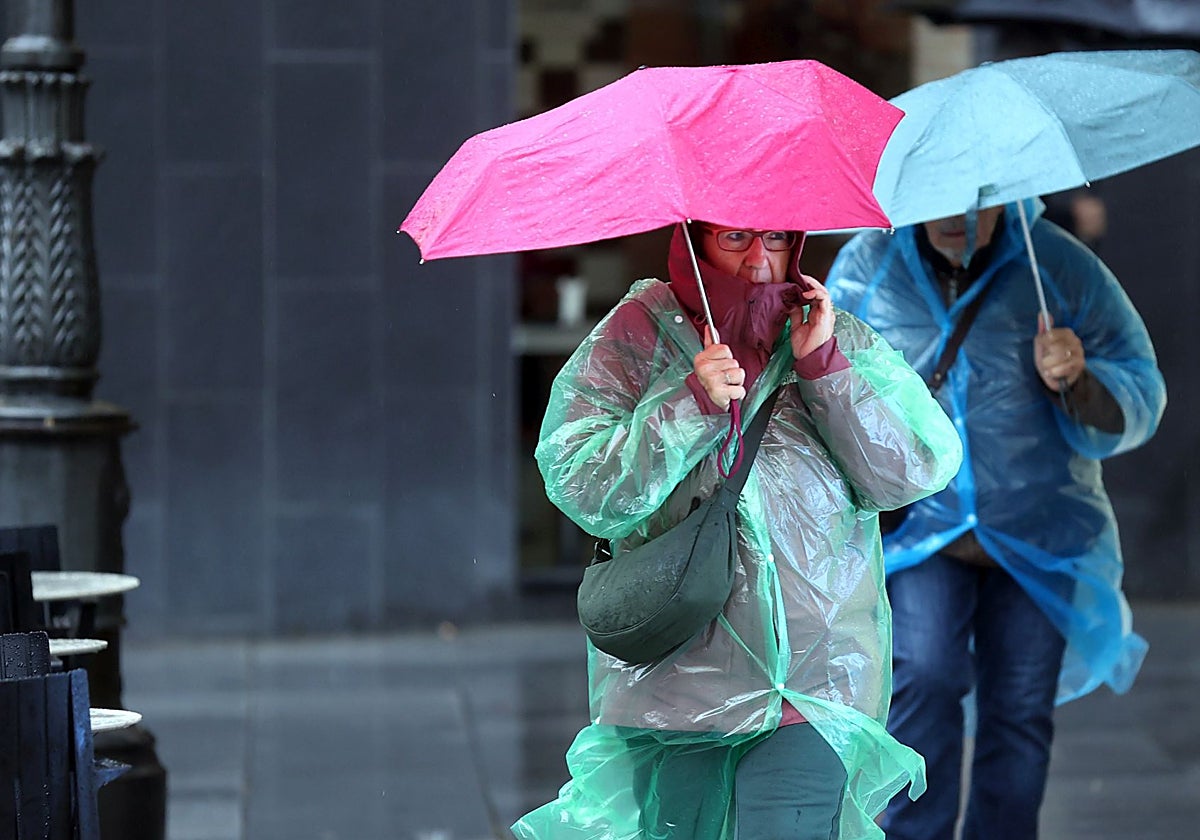 Dos personas se refugian de la lluvia en Córdoba