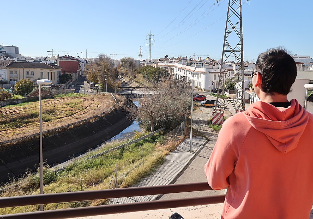 Un vecino contempla el paso del Canal del Guadalmellato por el barrio de San Rafael de la Albaida