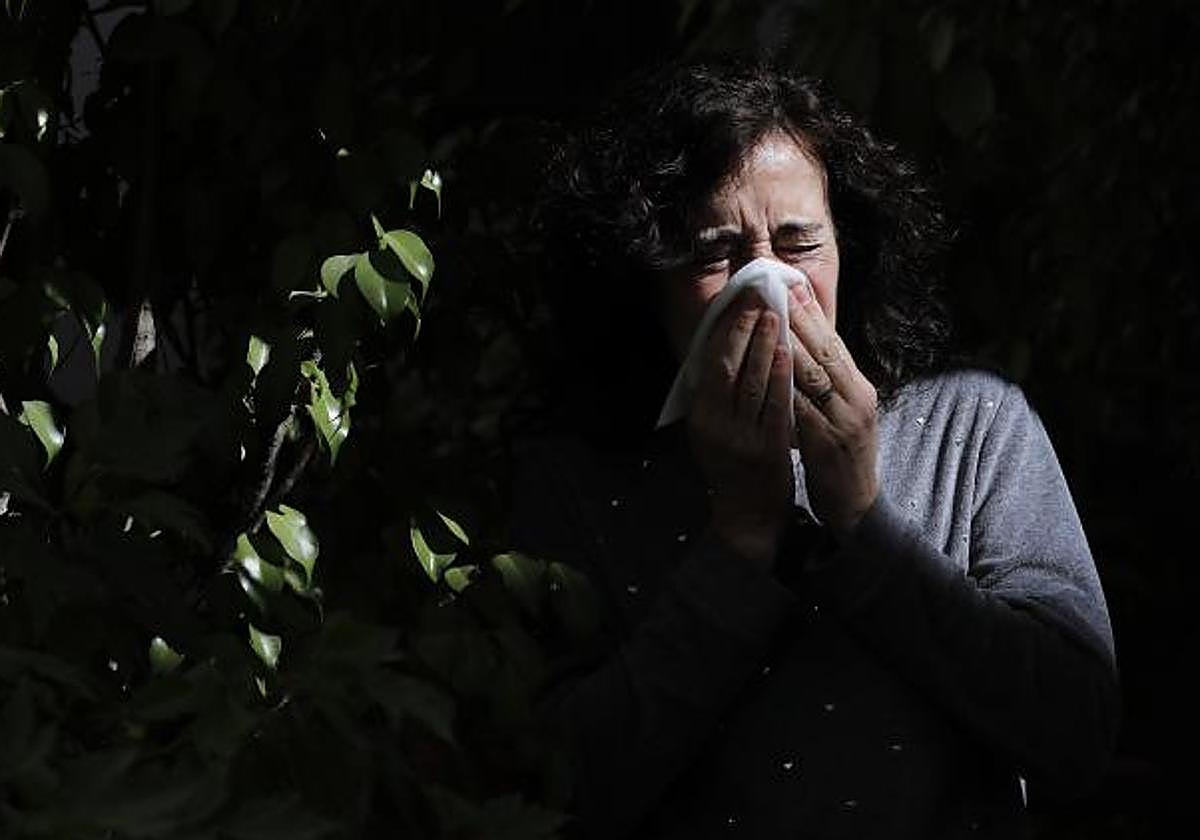 Una mujer estornudando por alergia ambiental