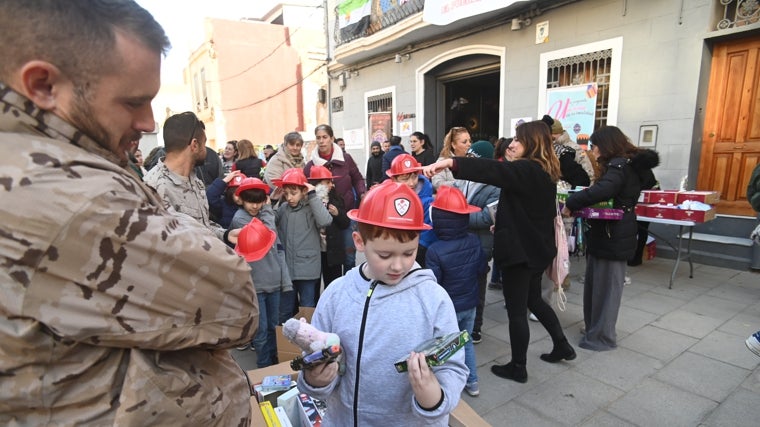 Imagen de un militar entregando regalos a un niño en Catarroja