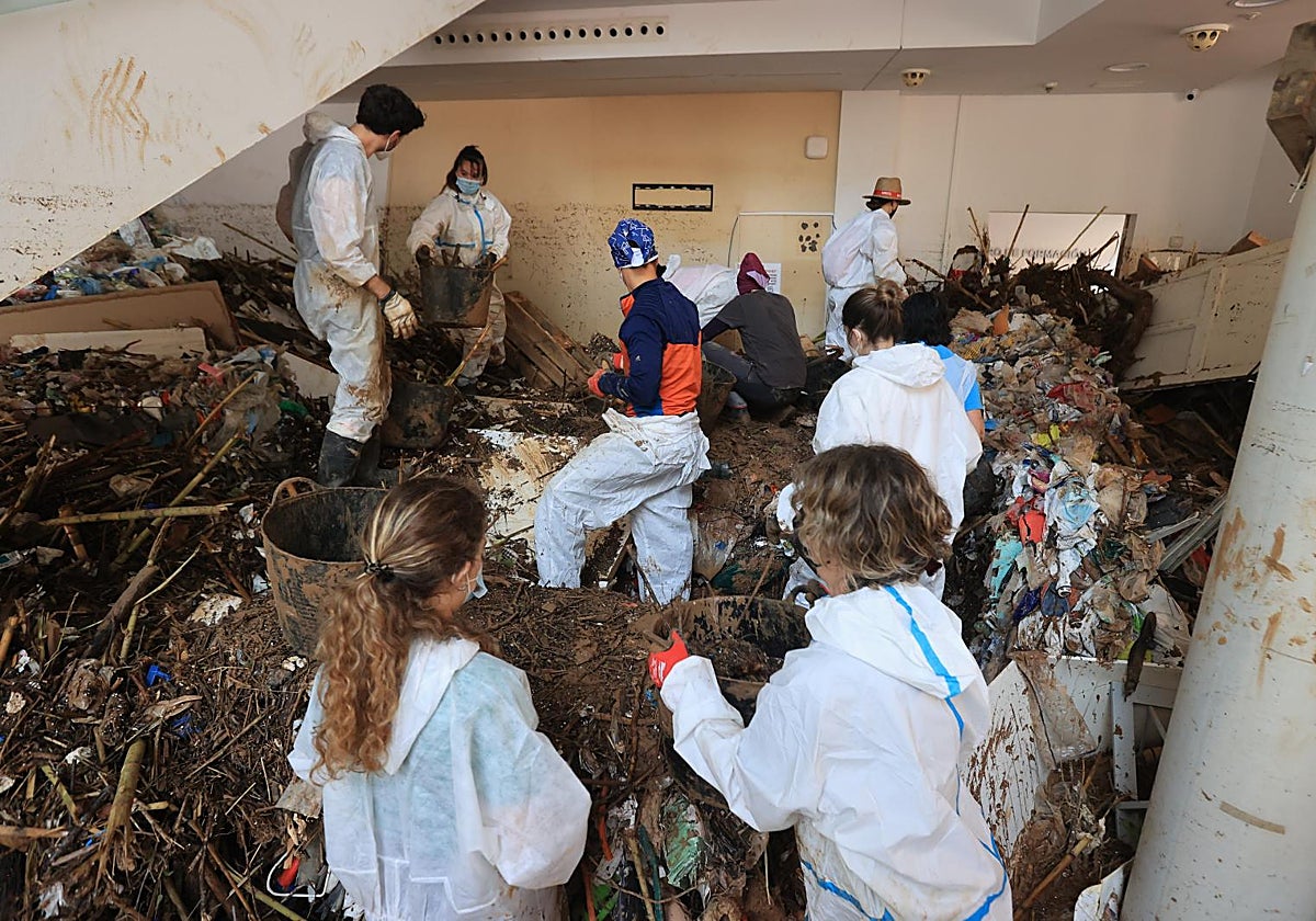 Imagen de archivo de voluntarios limpiando un bajo afectado por el paso de la DANA en Valencia