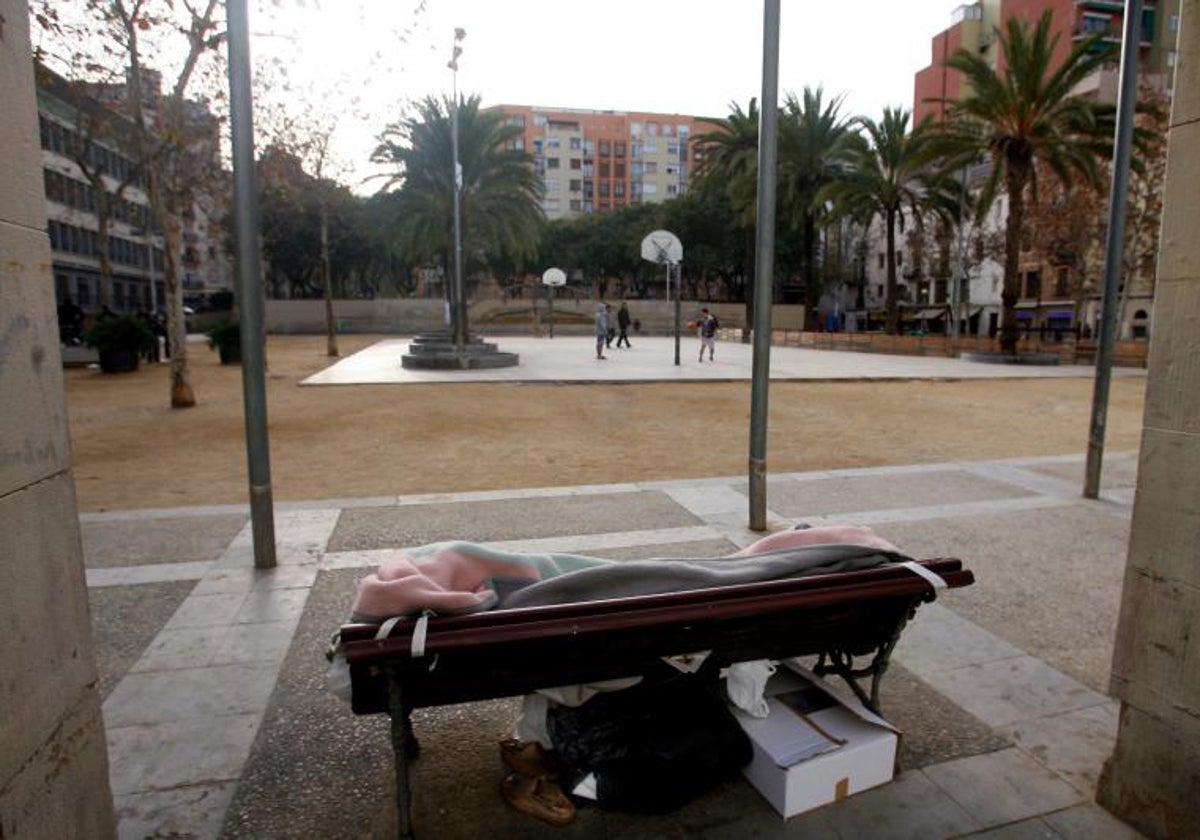 Una pesona sin hogar, durmiendo en un parque de Barcelona