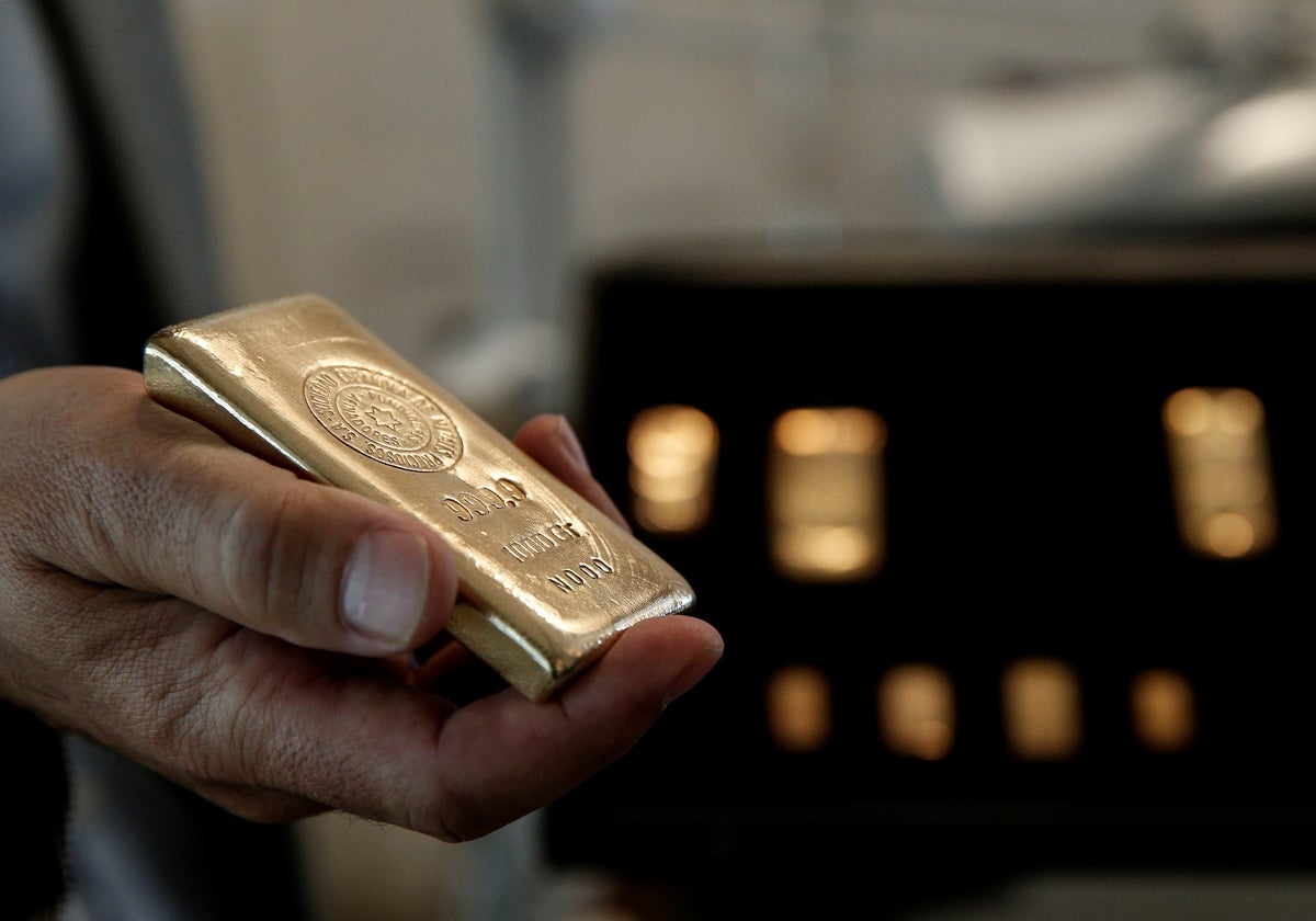 Una persona sostiene un lingote de oro