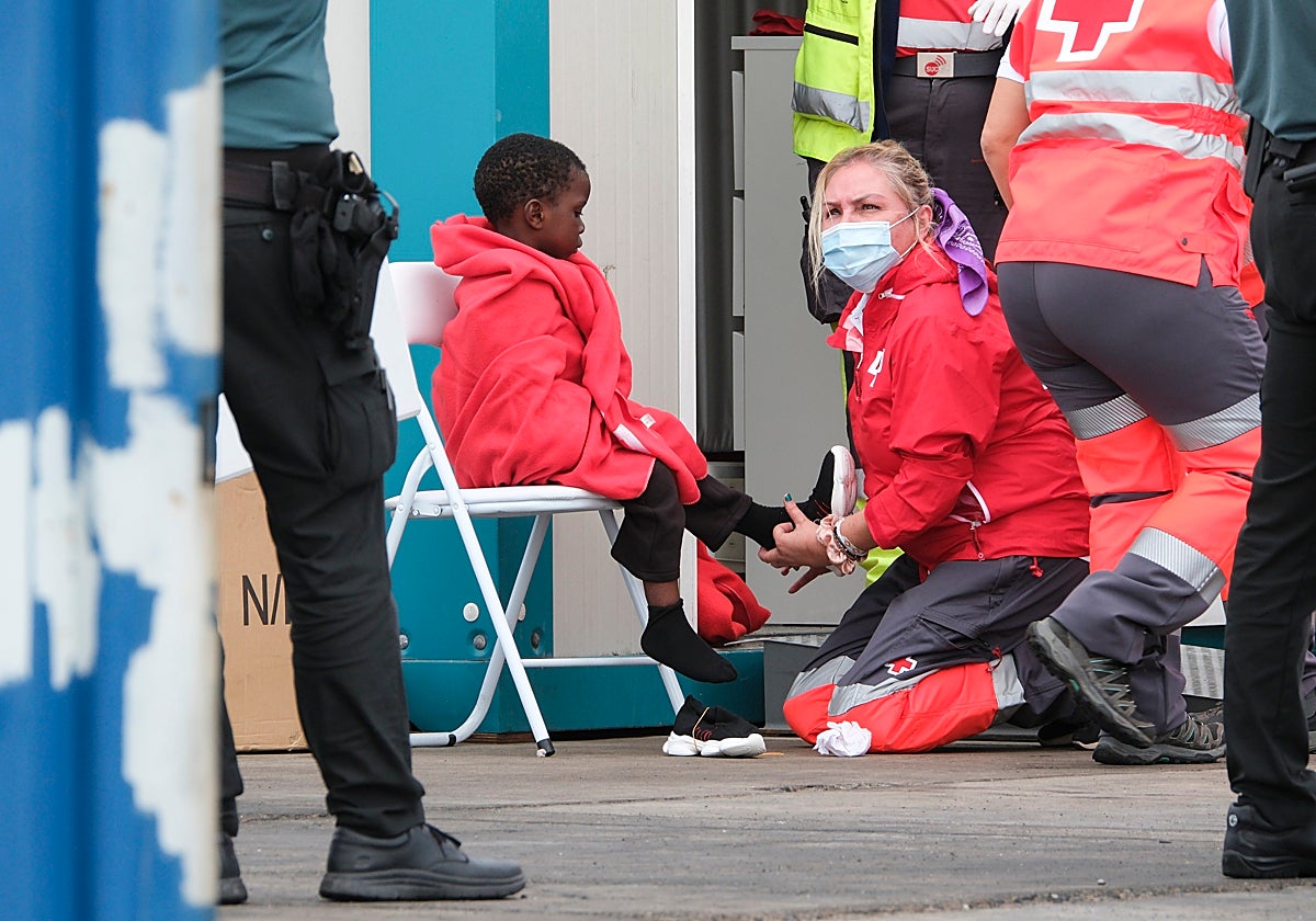 Un grupo de personas migrantes, entre ellos varios menores, es atendido por la Cruz Roja este martes en el puerto de Los Cristianos, después de que fueran rescatados por Salvamento Marítimo cerca de la isla de Tenerife.