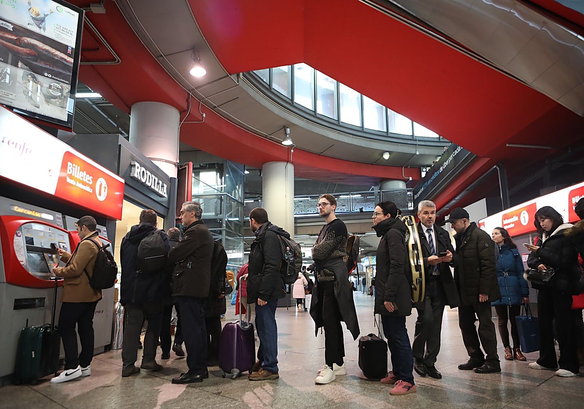 Algunos de los usuarios haciendo cola para comprar sus tarjetas en la estación de Atocha